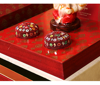 Exquisite Ganesha temple theme wedding invite in maroon colour