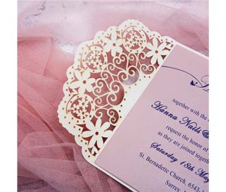 Laser cut wedding invitation in cream with ribbon bow and embellishments