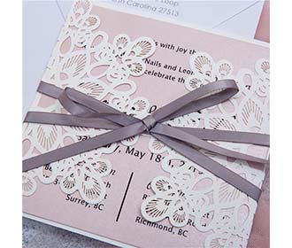White laser cut wedding invitation with grey ribbon