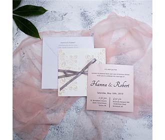 White laser cut wedding invitation with grey ribbon